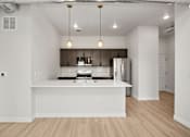 Thumbnail 1 of 42 - A modern kitchen with a white island and wooden floors.