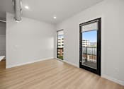 Thumbnail 6 of 42 - A room with a sliding glass door leading to a balcony.