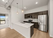 Thumbnail 2 of 42 - A modern kitchen with a white countertop and stainless steel appliances.