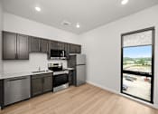 Thumbnail 26 of 42 - A kitchen with dark brown cabinets and stainless steel appliances.