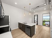 Thumbnail 30 of 42 - A modern kitchen with a large island and a view of the outdoors.