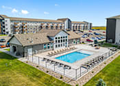 Thumbnail 1 of 38 - A large building with a pool in front.