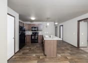 Thumbnail 72 of 81 - A kitchen with black appliances and a wooden floor.