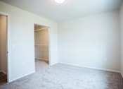 Thumbnail 7 of 21 - A room with a carpeted floor and a doorway leading to another room.