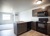 Thumbnail 8 of 21 - A kitchen with dark brown cabinets and appliances.