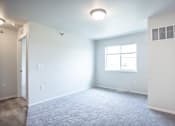 Thumbnail 12 of 21 - A room with a carpeted floor and a window.