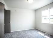Thumbnail 15 of 21 - A room with a grey carpet and a window with a white frame.