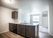 Thumbnail 16 of 21 - A kitchen with dark wood cabinets and a granite countertop.