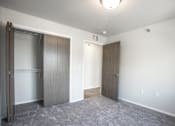 Thumbnail 18 of 21 - A room with two doors and a carpeted floor.