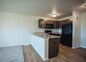 Thumbnail 5 of 21 - A kitchen with black appliances and wooden cabinets.