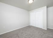 Thumbnail 20 of 22 - A room with a white door and carpeted floor.