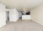 Thumbnail 15 of 22 - A large empty room with a carpeted floor and white walls.