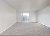 Thumbnail 17 of 22 - A large empty room with a carpeted floor and a doorway leading to another room.