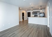 Thumbnail 4 of 21 - Modern open-concept kitchen and living area with black appliances.
