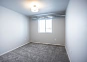 Thumbnail 21 of 21 - Bright, vacant bedroom with neutral walls and carpet flooring.