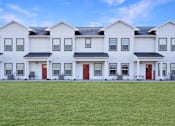 Thumbnail 13 of 73 - A row of white houses with red doors.