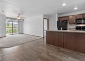 Thumbnail 17 of 38 - A kitchen with brown cabinets and a black countertop.