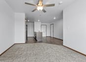 Thumbnail 19 of 38 - A room with a ceiling fan and a carpeted floor.