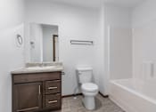 Thumbnail 30 of 38 - A white bathroom with a toilet, sink, and bathtub.