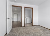 Thumbnail 32 of 38 - A white room with a brown door and a brown carpet.