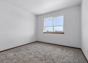 Thumbnail 31 of 38 - A room with a carpeted floor and a window showing a view of trees.