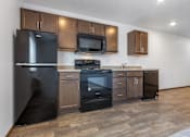 Thumbnail 20 of 38 - A kitchen with a black fridge, black oven, and black microwave.