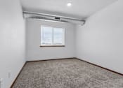 Thumbnail 36 of 38 - A room with a window and carpeted floor.