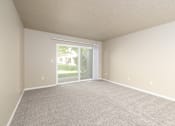 Thumbnail 14 of 41 - A room with a carpeted floor and a sliding glass door leading outside.