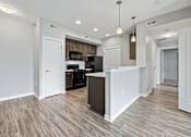 Thumbnail 5 of 29 - a renovated kitchen and living room with white walls and wood flooring