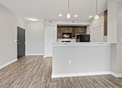 Thumbnail 15 of 29 - an kitchen and living room with a counter top and a refrigerator and a microwave