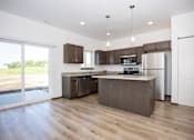 Thumbnail 4 of 59 - A modern kitchen with wooden floors and stainless steel appliances.