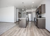 Thumbnail 32 of 54 - a kitchen and living room with wooden floors and stainless steel appliances