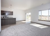 Thumbnail 23 of 54 - an empty living room with a kitchen and a large window