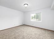 Thumbnail 6 of 35 - A room with a carpeted floor and a window.