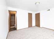 Thumbnail 8 of 35 - A room with a carpeted floor and two doors.