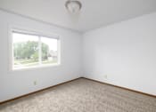 Thumbnail 23 of 35 - A room with a carpeted floor and a window.