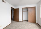 Thumbnail 25 of 35 - A room with two doors and a carpeted floor.