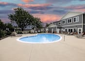 Thumbnail 14 of 35 - A swimming pool in a backyard with a house in the background.