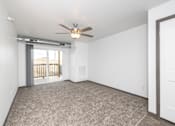 Thumbnail 13 of 58 - A room with a ceiling fan and carpeted floor.