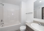 Thumbnail 28 of 58 - A white bathroom with a toilet, sink, and bathtub.