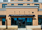 Thumbnail 3 of 50 - A brick building with a black awning that says An F RPMand ReBuild Metro Community.