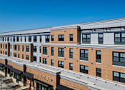 Thumbnail 6 of 50 - A large building with a flat roof and a lot of windows.