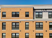 Thumbnail 4 of 50 - A building with a red brick facade and a white awning.