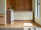 Thumbnail 11 of 50 - A reception desk with a row of drawers and a plant on top.