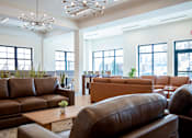 Thumbnail 12 of 50 - A large room with brown leather couches and a wooden table in the middle.