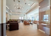 Thumbnail 16 of 50 - A modern living room with brown furniture and a chandelier.