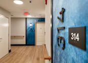 Thumbnail 18 of 50 - A hallway with a blue wall and a sign that says 314.