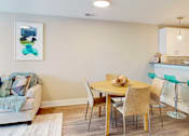 Thumbnail 22 of 50 - A dining room with a table set for two and a couch with a throw on it.