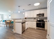 Thumbnail 29 of 50 - A modern kitchen with a dining table and chairs.