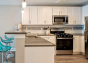 Thumbnail 33 of 50 - A kitchen with white cabinets and a stainless steel refrigerator.